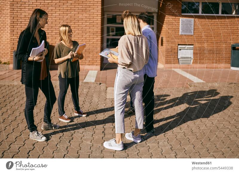 Group of students standing outdoors with documents group of people groups of people studying persons human being humans human beings higher education