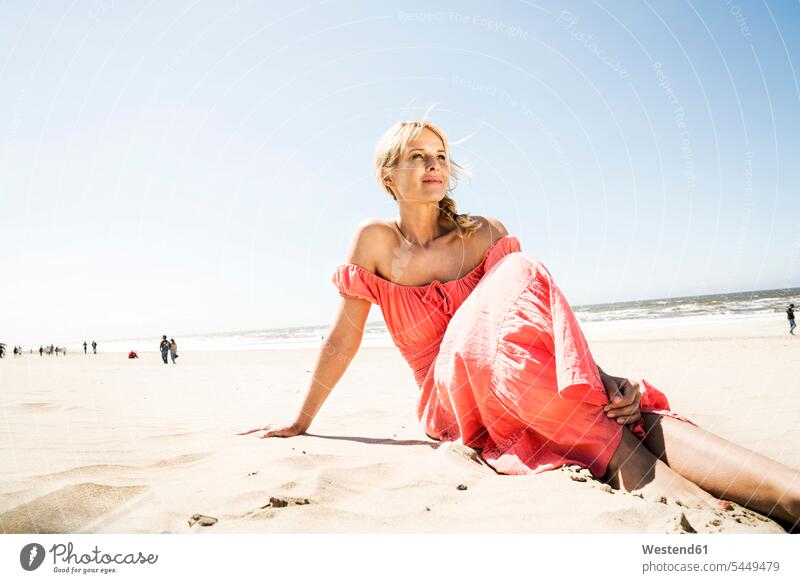 Woman in dress sitting on the beach beaches Seated woman females women Adults grown-ups grownups adult people persons human being humans human beings vacation