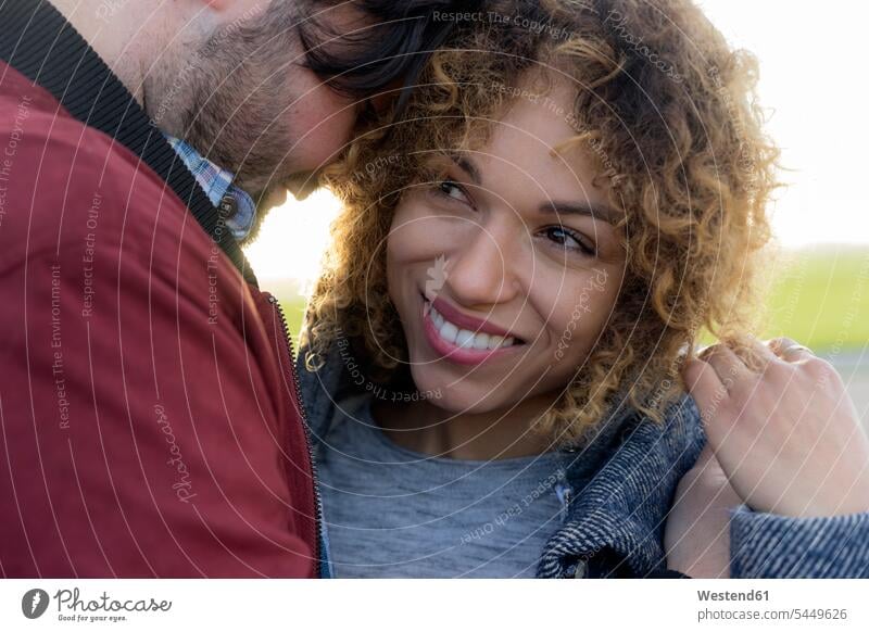 Portrait of smiling young couple close together outdoors portrait portraits smile twosomes partnership couples closeness propinquity people persons human being