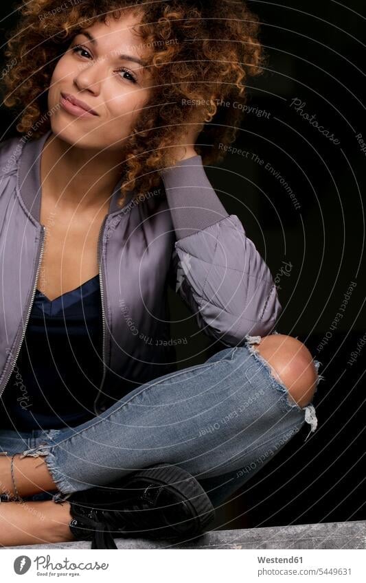 Portrait of smiling woman sitting against black background females women smile Seated portrait portraits Adults grown-ups grownups adult people persons