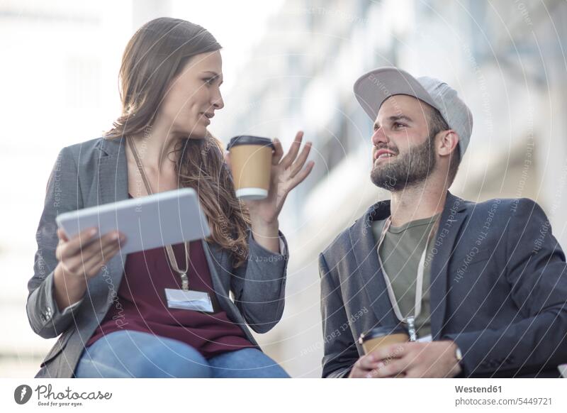 Young man and woman with tablet and coffee to go talking outdoors colleagues speaking Coffee digitizer Tablet Computer Tablet PC Tablet Computers iPad