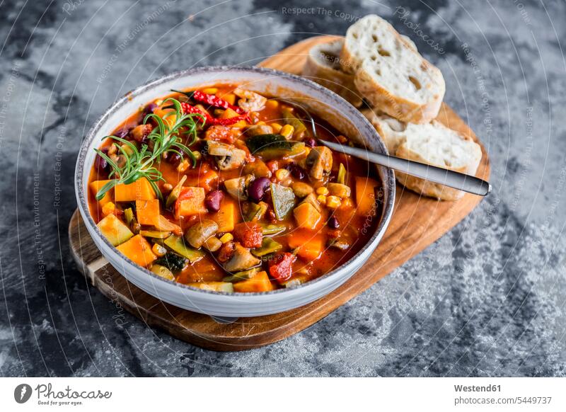 Vegetable chili with kidney bean, sweet potatoe, champignon, corn, snow pea, baguette in bowl Bowl Bowls Slice Slices hearty savoury food lusty garnished maize