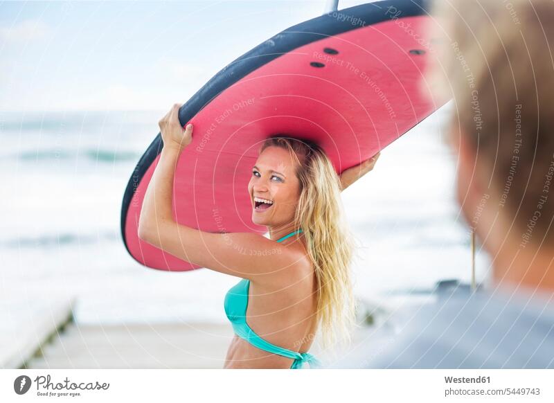 Happy woman carrying surfboard beach beaches surfing surf ride surf riding Surfboarding laughing Laughter walking going surfboards females women water sports