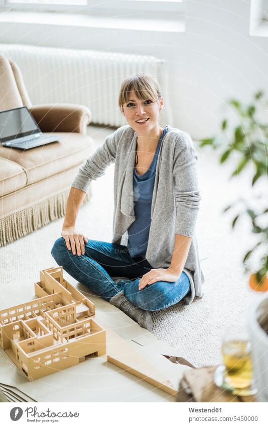 Portrait of smiling woman in office with architectural model Office Offices portrait portraits models smile Architecture females women Adults grown-ups grownups