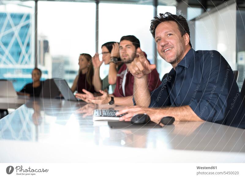 Business people sitting in conference room Office Offices meeting room conference rooms meeting rooms Business Meeting business conference Seated smiling smile