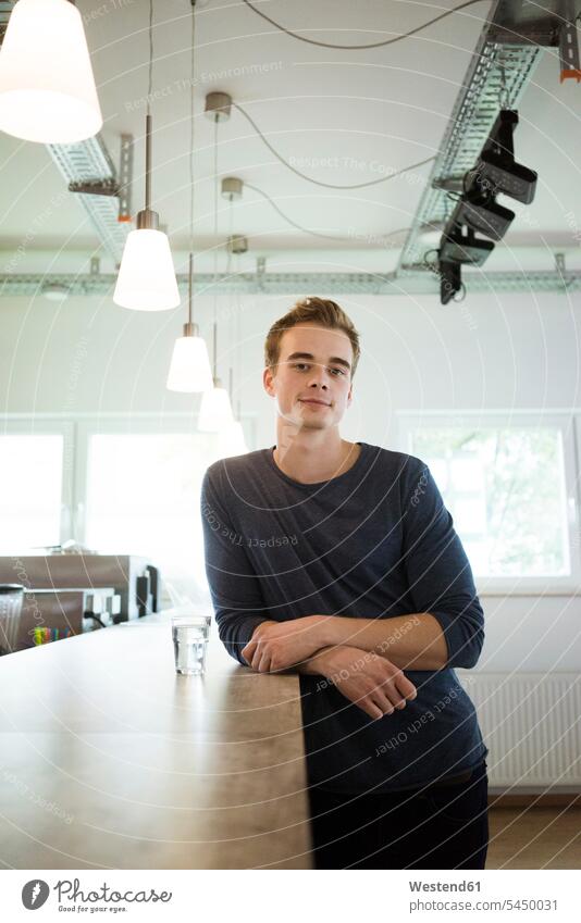 Portrait of smiling young man in a coffee shop student students men males portrait portraits counter counters cafe Adults grown-ups grownups adult people