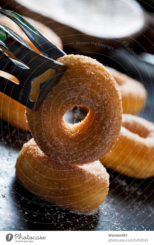 Pastry tong holding mini doughnut, close-up nobody tilted slanted circle circles circular sweet Sugary sweets pastry tong pastry tongs baked Baked Food