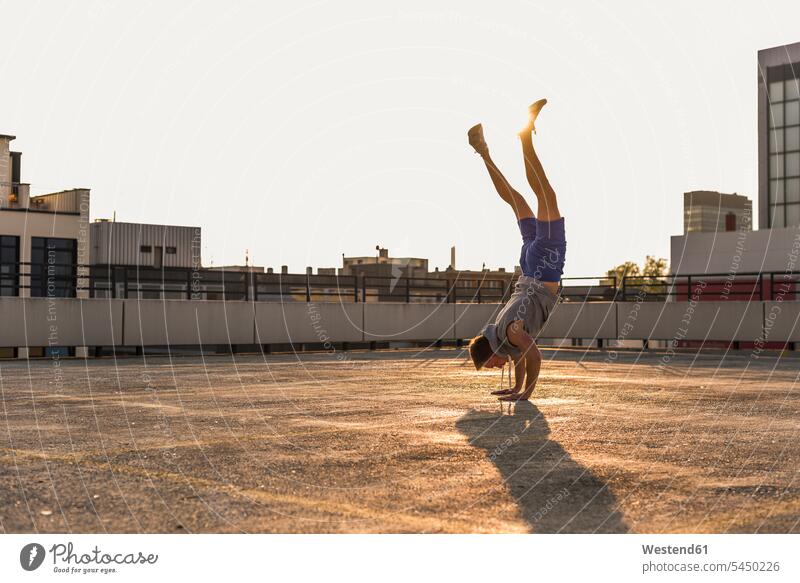 Young man exercisng handstand young fit men males Adults grown-ups grownups adult people persons human being humans human beings exercising exercise training