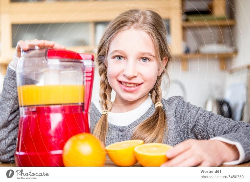 Portrait of smiling girl making freshly squeezed orange juice smile kitchen domestic kitchen kitchens females girls Orange Oranges child children kid kids