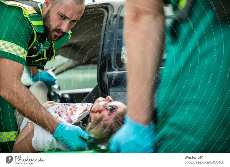 Paramedics moving car crash victim on stretcher paramedic paramedics carrying transporting accident injury Physical Injury injuries patient