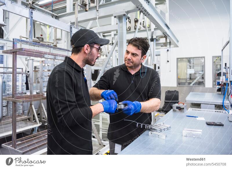 Two men working in factory shop floor colleagues factories man males At Work worker blue collar worker workers blue-collar worker Adults grown-ups grownups