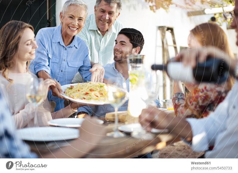 Happy family having lunch together outside Garden Party Garden Parties celebrating celebrate partying Fun having fun funny happiness happy families Celebration