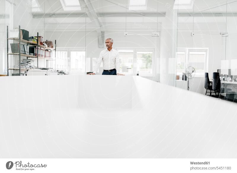 Mature businessman at conference table in office thinking conference room meeting room conference rooms meeting rooms Businessman Business man Businessmen