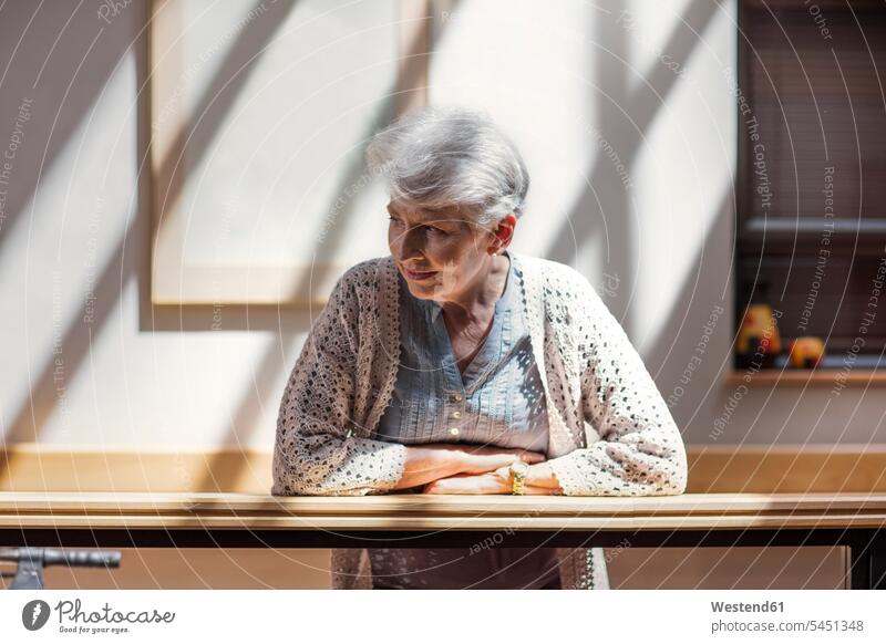 Lonely senior woman leaning on railing, looking down rested on senior women elder women elder woman old Railing Railings watching observing observe sad