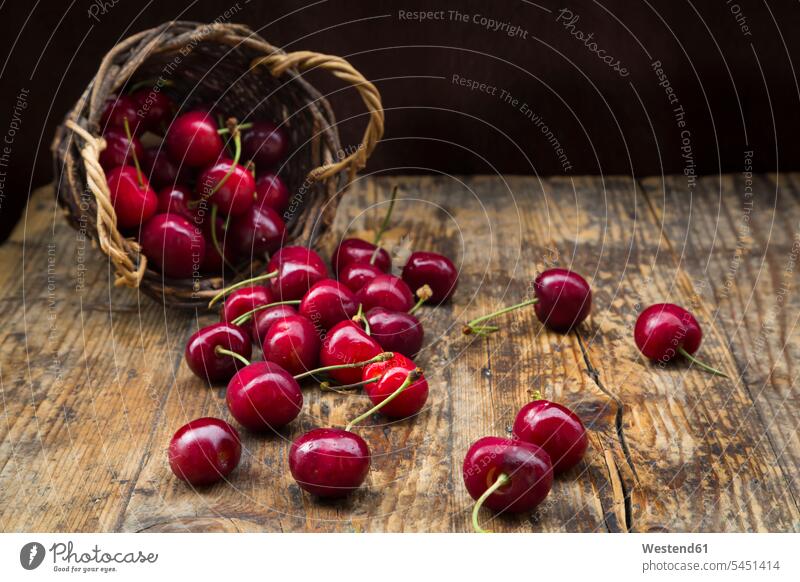 Wickerbasket of cherries on wood food and drink Nutrition Alimentation Food and Drinks stalk Stipes Plant Stem stalks Stems Plant Stems wooden wickerbasket