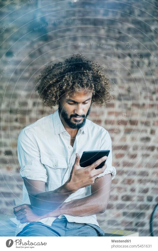 Young man checking his tablet Businessman Business man Businessmen Business men serious earnest Seriousness austere digitizer Tablet Computer Tablet PC