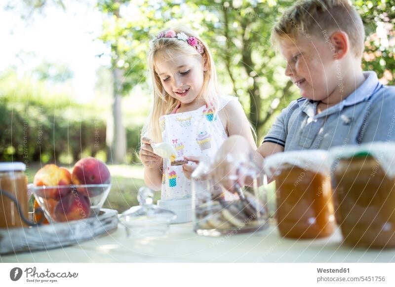 Smiling sister and brother at garden table sisters brothers smiling smile siblings brother and sister brothers and sisters family families people persons