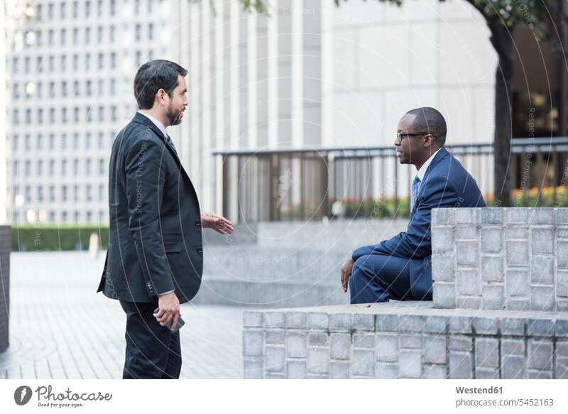 Two businessmen talking outdoors Businessman Business man Businessmen Business men colleagues speaking business people businesspeople business world