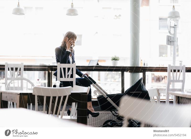 Businesswoman working from cafe with pram on her side sitting Seated At Work tablet digitizer Tablet Computer Tablet PC Tablet Computers iPad Digital Tablet