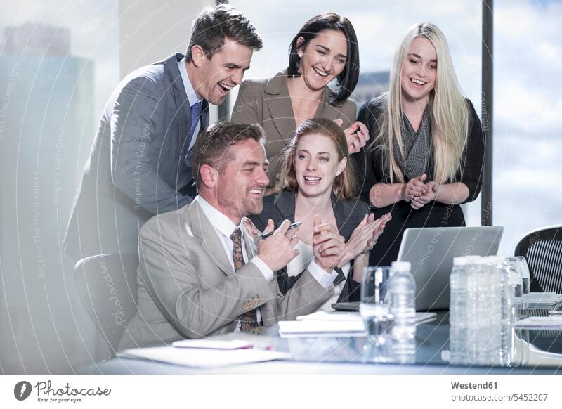 Group of happy with laptop in boardroom Businessman Business man Businessmen Business men colleagues group of people groups of people happiness office offices