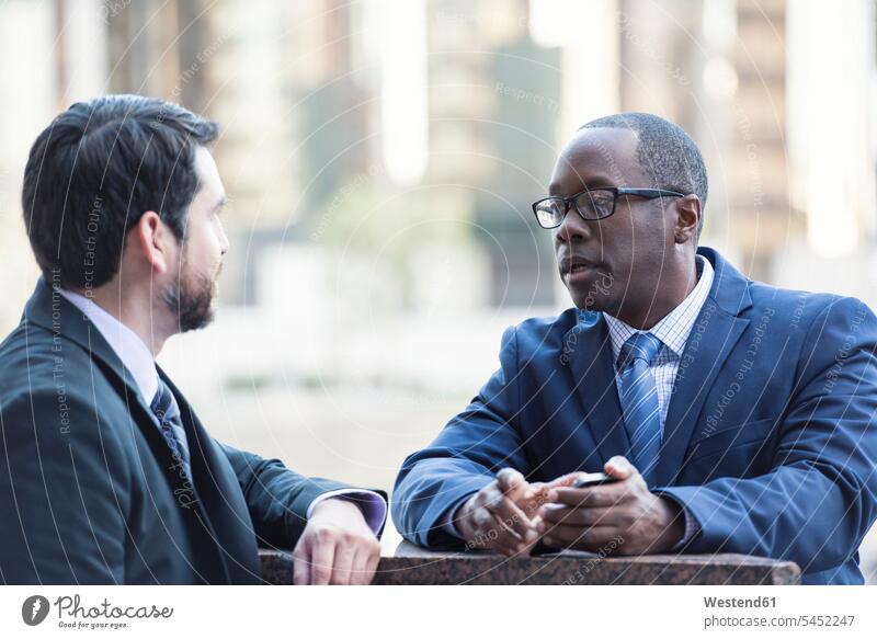 Two businessmen talking outdoors colleagues Businessman Business man Businessmen Business men speaking business people businesspeople business world