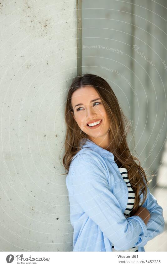 Portrait of a young woman leaning on a wall females women laughing Laughter walls portrait portraits Adults grown-ups grownups adult people persons human being