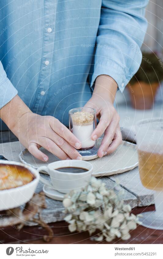 Italy, woman arranging glass of dessert on breakfast table, partial view Breakfast Table Tables terrace terraces hand human hand hands human hands Dessert