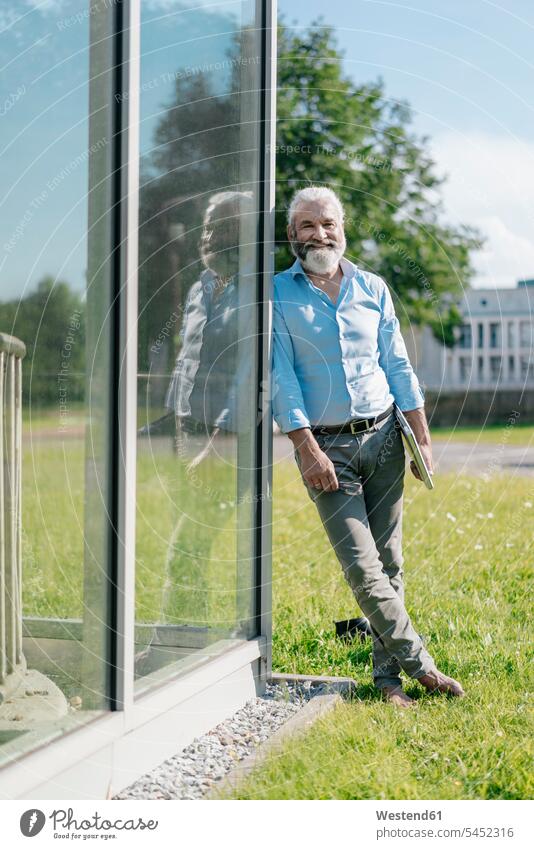 Portrait of smiling mature man standing outdoors holding laptop smile Laptop Computers laptops notebook meadow meadows men males computer computers Adults