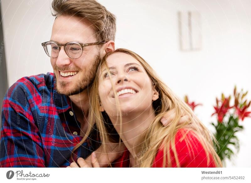 Happy young couple at home happiness happy twosomes partnership couples people persons human being humans human beings portrait portraits arm around arms around