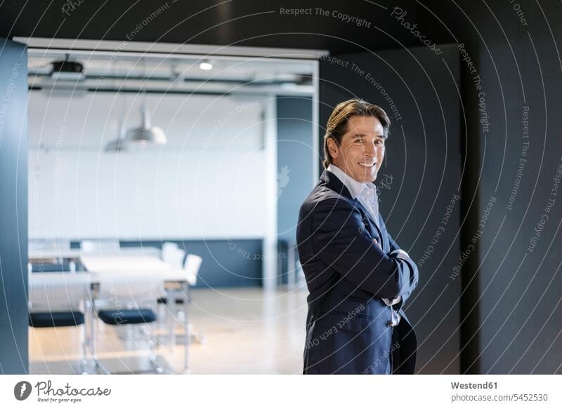 Portrait of smiling businessman standing on office floor portrait portraits smile offices office room office rooms Businessman Business man Businessmen