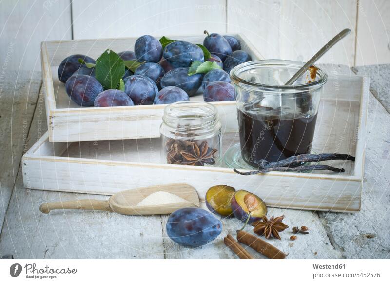 Preserving jar of plum jam, plums and ingredients on wood uncooked close-up close up closeups close ups close-ups cinnamon stick cinnamon sticks half halves