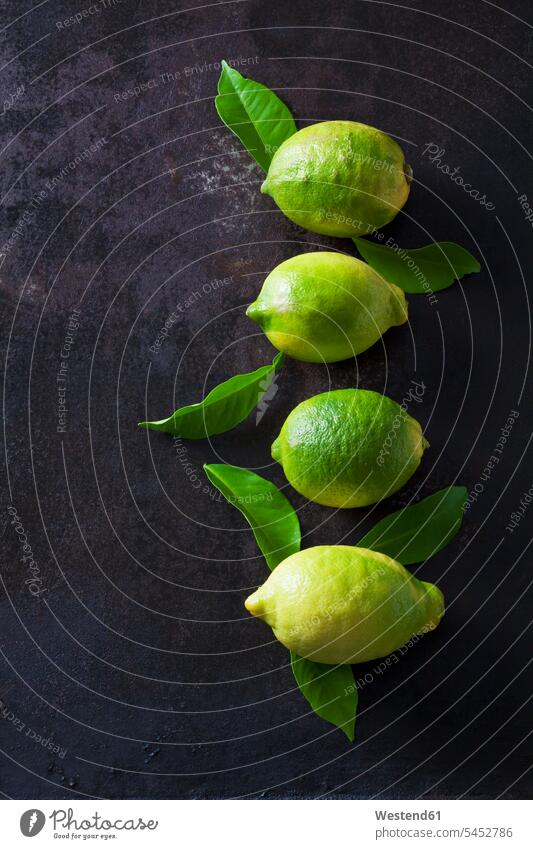 Green organic lemons on dark background overhead view from above top view Overhead Overhead Shot View From Above Lemon Lemons organic edibles Leaf Leaves green