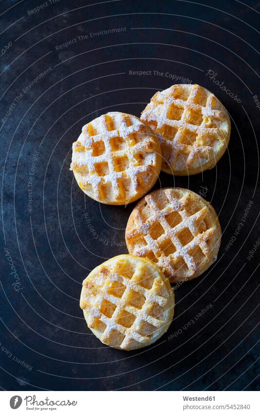 Four waffles sprinkled with icing sugar circle circles circular dark background four objects 4 homemade home made home-made powdered sugar sweet Sugary sweets