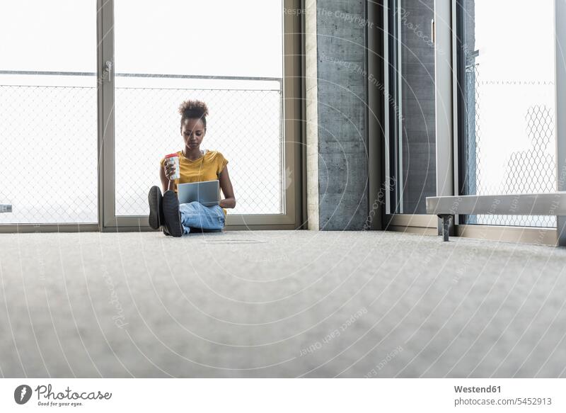 Young woman sitting on floor using laptop Laptop Computers laptops notebook Seated females women computer computers Adults grown-ups grownups adult people