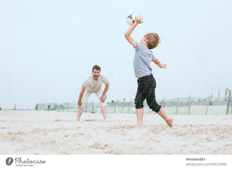 Father and little son playing with ball on the beach sons manchild manchildren beaches father pa fathers daddy dads papa family families people persons