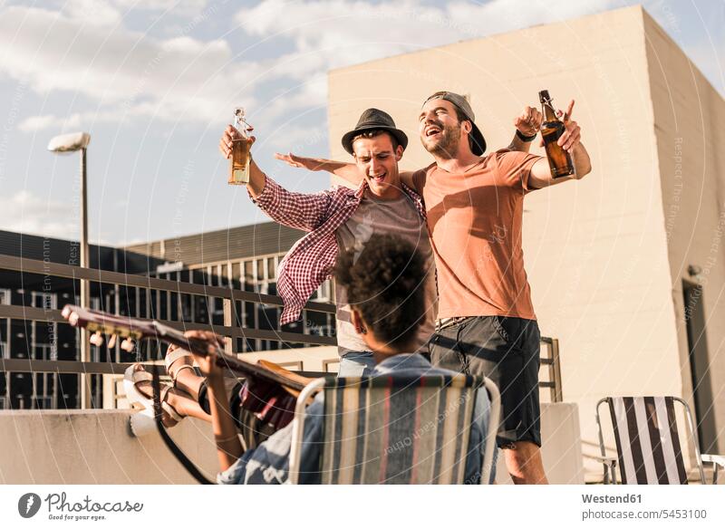 Three friends having a rooftop party drinking Party Parties celebrating celebrate partying Beer Beers Ale Fun having fun funny roof terrace deck Celebration