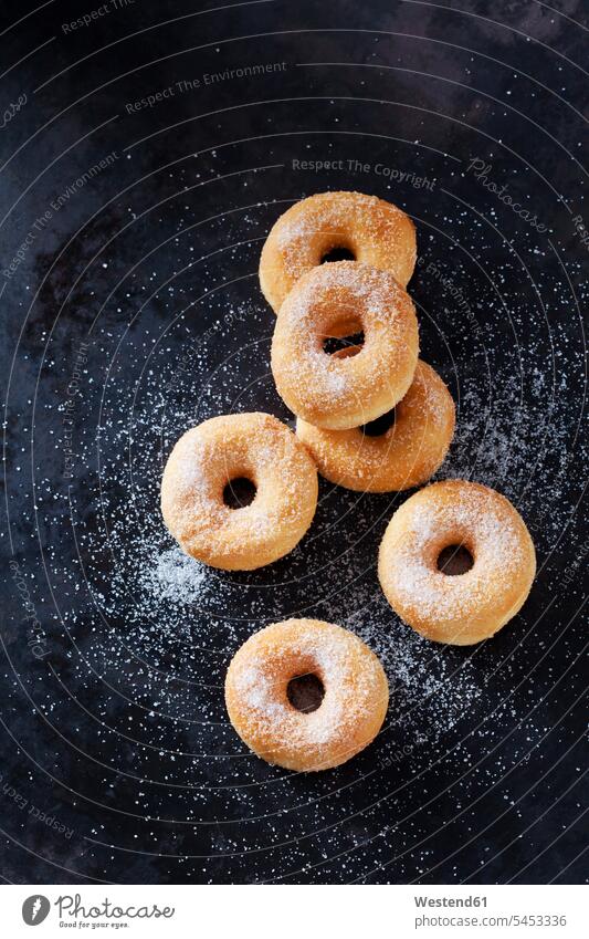 Six mini doughnuts sprinkled with sugar on dark ground nobody enjoyment indulgence Pastry Pastries donuts Doughnuts baked goods pastries Baked Food scattered