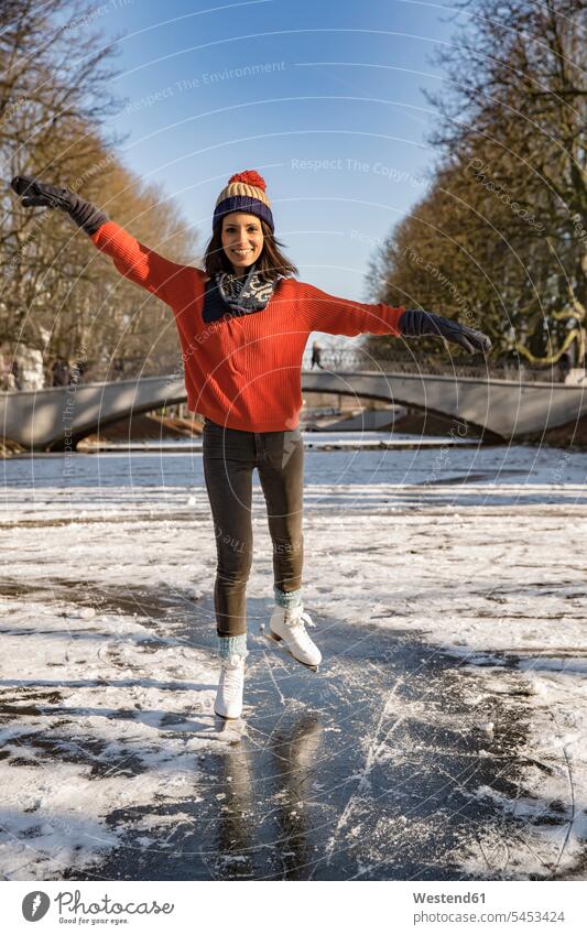 Woman ice skating on canal woman females women smiling smile Adults grown-ups grownups adult people persons human being humans human beings Arms outstretched