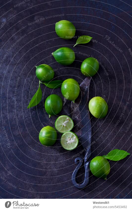 Sliced and whole limequats, leaves and old knife on dark ground nobody Citrus Fruit Citrus Fruits green large group of objects many objects Leaf Leaves