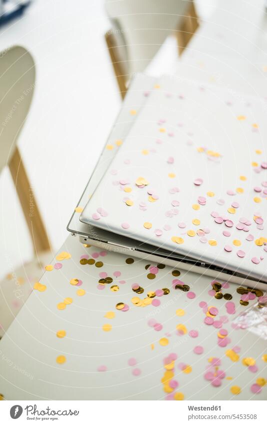 Confetti on desk with laptop in office offices office room office rooms desks Laptop Computers laptops notebook confetti workplace work place place of work