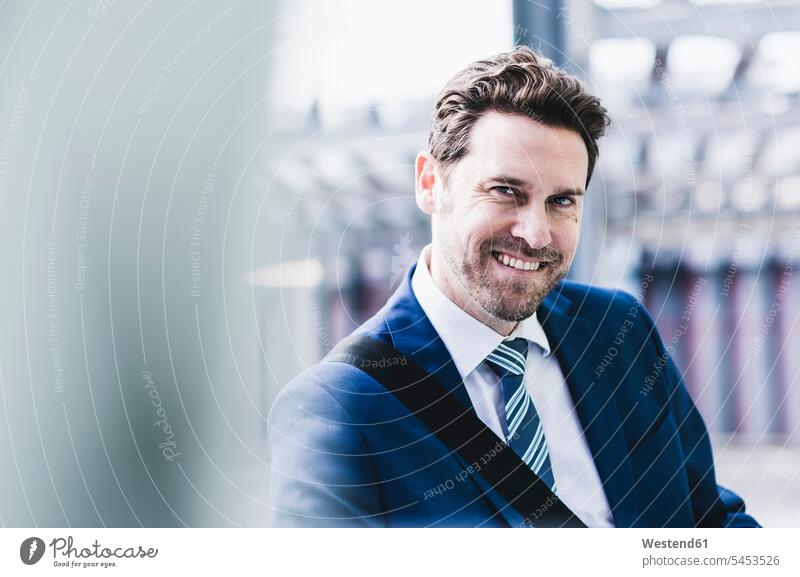 Businessman standing on parking level, portrait Business man Businessmen Business men parking garage parking garages parking deck car park parking place