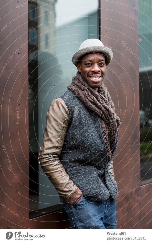 Portrait of smiling man leaning against facade portrait portraits men males Adults grown-ups grownups adult people persons human being humans human beings