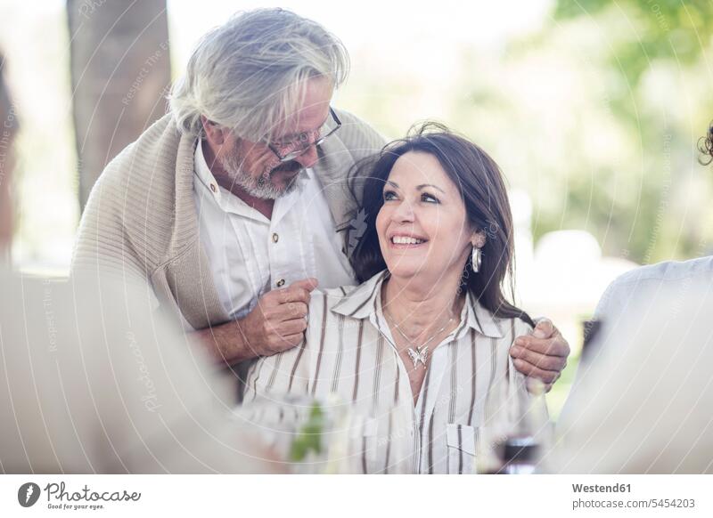 Senior man embracing his wife at outdoor table couple twosomes partnership couples people persons human being humans human beings senior couple elder couples