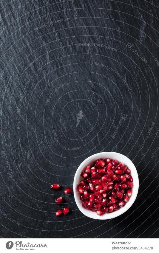 Bowl of pomegranate seed on slate food and drink Nutrition Alimentation Food and Drinks close-up close up closeups close ups close-ups red Fruit Fruits Bowls