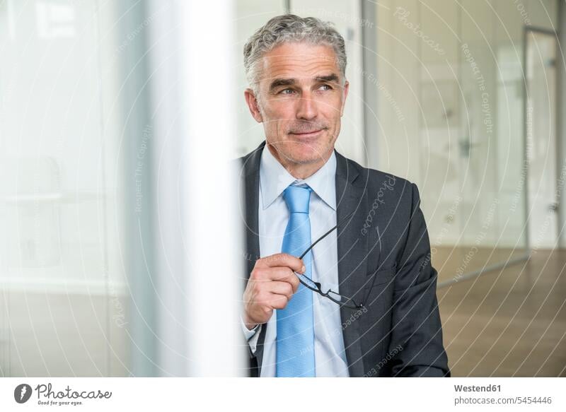 Portrait of a mature businessman, holding glasses standing respectable reliable specs Eye Glasses spectacles Eyeglasses Businessman Business man Businessmen