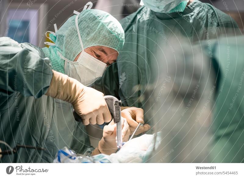 Neurosurgeons opening the cranium during an operation surgery surgeries operating doctor physicians doctors treatment Medical Treatment treatments