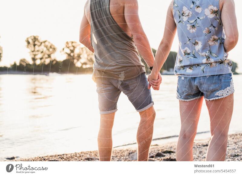 Young couple walking at the riverbank going twosomes partnership couples people persons human being humans human beings River Rivers water waters body of water