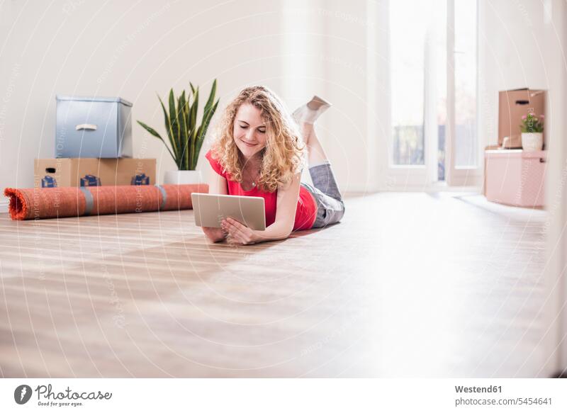 Young woman in new home lying on floor with tablet digitizer Tablet Computer Tablet PC Tablet Computers iPad Digital Tablet digital tablets laying down lie