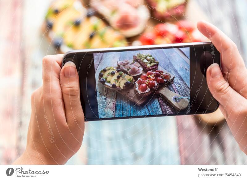 Girl photographing with her smartphone, various sandwiches on chopping board girl females girls Bread Breads photographs photos Smartphone iPhone Smartphones