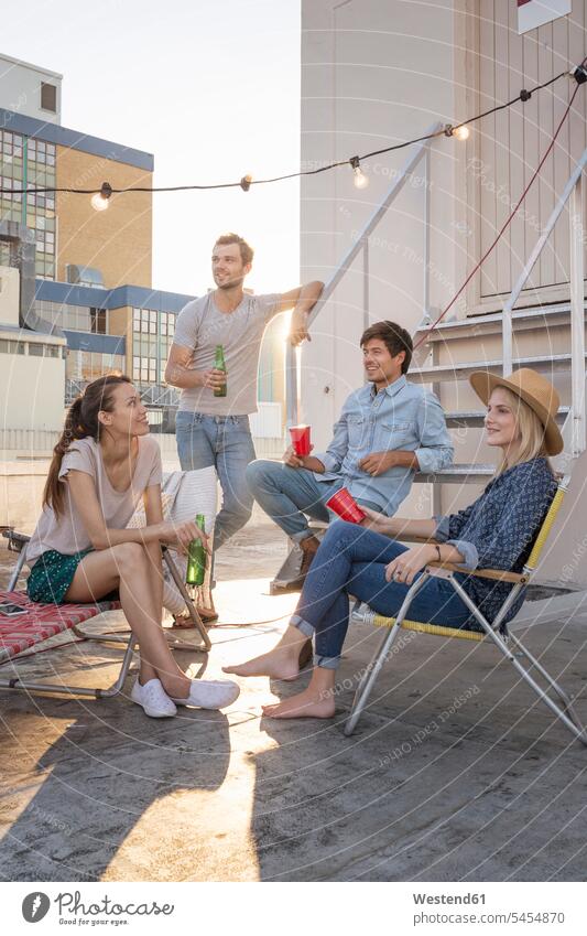 Friends having a rooftop party on a beautiful summer evening cheerful gaiety Joyous glad Cheerfulness exhilaration merry gay summer time summery summertime Fun